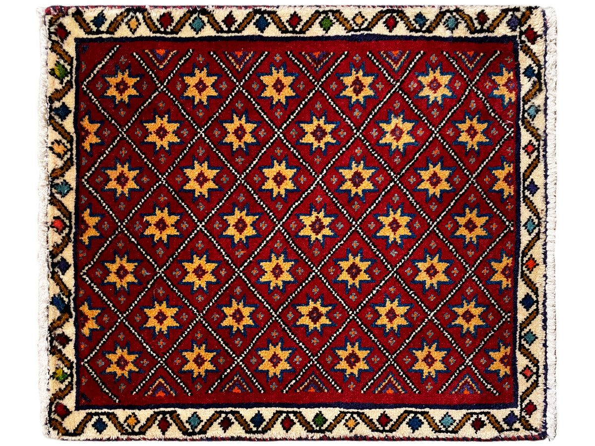 Tapis carré avec motif rouge et motif géométrique multicolore en forme d’étoile composée de carreaux